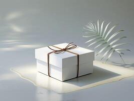 Simple White Square Box Tied with Brown Twine on Gray Surface with Palm Leaf photo