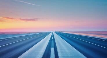 An empty highway with a sunset in the background photo