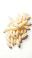 Closeup view of raw rice grains on a plain surface highlighting their texture and shape photo