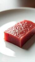 Closeup view of fresh red tuna on a white plate ready for culinary preparation photo