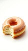 Closeup of a glazed donut with a bite taken from it on a light background photo