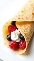 Delicious closeup of rolled crepe filled with fresh berries and whipped cream photo