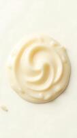 Closeup view of creamy substance with smooth swirls on a light background photo