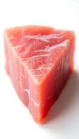 Closeup view of a triangular slice of fresh sushi-grade fish on a clean surface photo