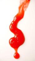 Closeup view of smooth red ketchup flowing across a plain surface photo