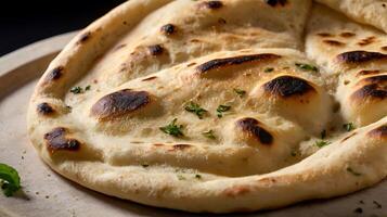 Closeup view of a freshly baked naan bread with golden brown spots and herbs photo