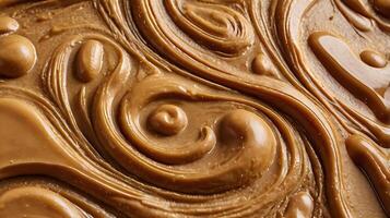 Closeup view of rich, textured layer of smooth caramel swirl pattern on a surface photo