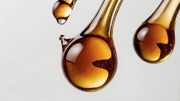 Extreme closeup of a drop of maple syrup showcasing its thick texture and rich color photo