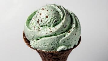 Closeup view of mint chocolate chip ice cream swirl in a cone with chocolate flecks photo