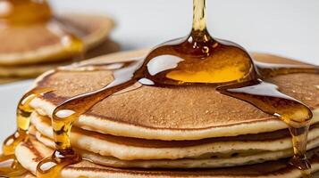 Delicious pancake stack with syrup dripping in closeup on a white background photo