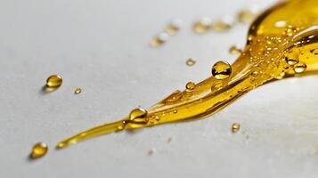 Closeup view of a single liquid droplet on a flat surface with golden hues shining through photo