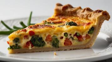 Closeup view of a delicious slice of quiche with fresh vegetables on a plate photo