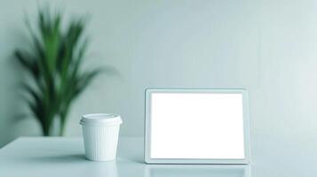 Marketing analytics data personalization concept. Blank tablet and coffee cup on a minimalistic table with greenery. photo