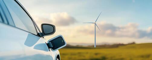 Renewable Energy wind integration concept. Electric car charging near wind turbine in a scenic landscape. photo