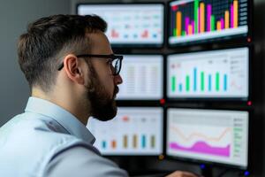 Marketing analytics strategy behavior concept. Professional man analyzing data on multiple screens in an office setting. photo