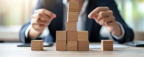 Climbing corporate ladder concept. Building blocks arranged on a table with hands strategically placing them. photo