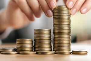 Motivated corporate ladder concept. Hands stacking coins in a rising bar chart formation. photo