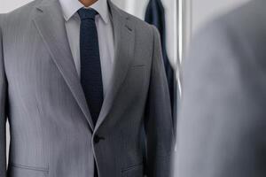 Custom fit clothes concept. Stylish man in a tailored suit looking in a mirror. photo