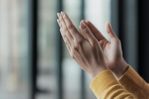 Hands clapping in appreciation, wearing a cozy sweater, with a blurred background. photo
