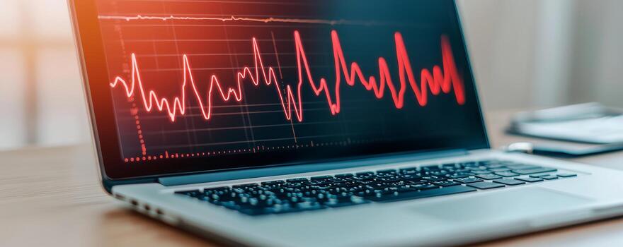 Laptop displaying a red heartbeat graph, symbolizing health monitoring and data analysis. photo