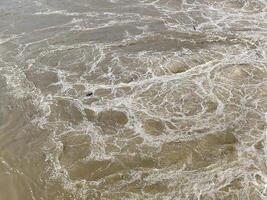 Turbulent Water Surface with Floating White Foam Patterns photo