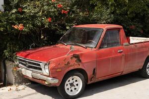 red old car under blooming tree, rust and corrosion of car metal photo