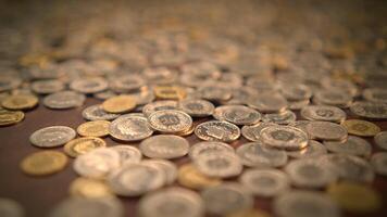 An assortment of scattered coins placed on a varied surface in an artistic arrangement video