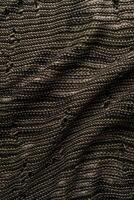 A close-up view of intricately woven fabric, blending dark and light threads to form a detailed pattern. Ideal for textile design projects. photo