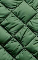 Close-up of green quilted fabric with a diamond pattern, showing detailed stitching and texture. photo