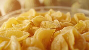 A close-up of yellow pasta shapes in a bowl, with a soft background. photo