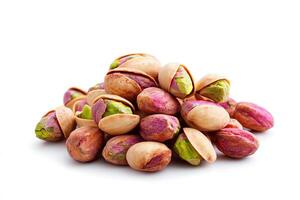 A close-up view of a pile of pistachio nuts showcasing their vibrant colors and unique textures against a clean white background, perfect for culinary and snack-related themes. photo