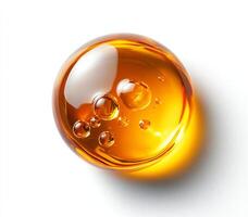 A close-up view of a round drop of amber-colored liquid, showcasing the smooth surface and air bubbles trapped within, perfect for food-related themes or liquid textures. photo