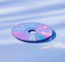 A close-up view of a shiny, iridescent CD resting on a reflective surface, showcasing its vibrant colors and patterns photo