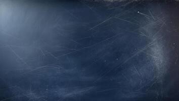 A copy space image of a dark blue chalkboard with traces of erasing creating a textured background. photo