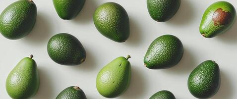 Avocados are arranged in a pattern on a white surface photo