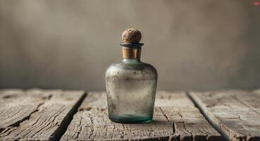An old glass bottle with a wooden stopper on a wooden table photo