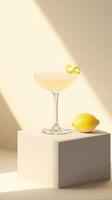 Refreshing cocktail served in a modern glass with a twist of lemon on a minimalistic display photo