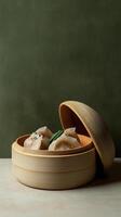 Freshly made dim sum in a bamboo basket showcased against a textured green background photo