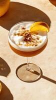 Cocktail garnished with a lemon slice and foam, presented on a curved surface surrounded by fresh ingredients photo