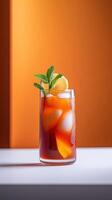 Vibrant turmeric iced tea garnished with fresh lemon and mint served in a clear glass on a sunny table photo