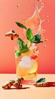 Refreshing lemonade with fresh mint and ginger on a vibrant orange background photo