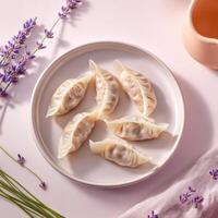 Pork and cabbage dumplings arranged on a plate with lavender and soft fabric accents photo
