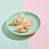 Delicately sliced cabbage and pork dumplings served on a pastel plate during a vibrant culinary presentation photo