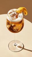 Refreshing limoncello spritz cocktail served in a clear glass with ice and a twist of lemon on a sunny table photo