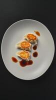 Explore delicious dumplings served with flavorful soy sauce on a minimalist plate for an elegant dining experience photo