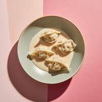 Delicious dumplings in creamy sauce beautifully arranged on a pastel plate photo