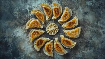 Modern composition of pan-seared dumplings arranged artistically on a textured surface photo