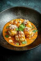 Delicious dumplings drizzled in a rich sauce served in a unique plate for an appetizing dining experience photo