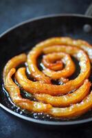 Sizzling pan with golden-crisp guo tie arranged in a circular pattern ready to be enjoyed at a bustling kitchen photo