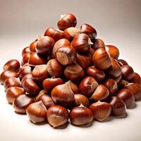 A large pile of shiny brown chestnuts, freshly harvested and ready to be roasted or used in culinary delights photo